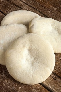Four loaves of Arabic bread on the wooden table