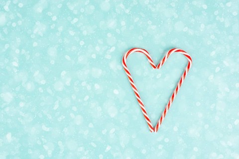 Candy cane forms heart shape, Christmas holiday background, winter season greeting card