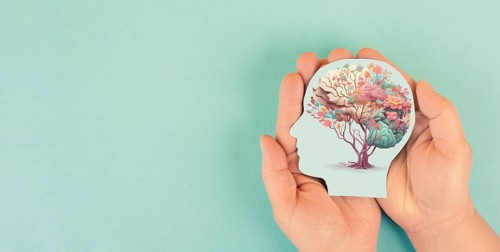 Hands holding head, human brain with flowers, self care and mental health concept, positive