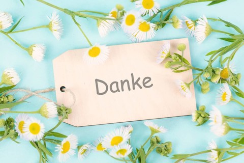 Thanks card surrounded by flowers, german language, being thankful, support, help and charity