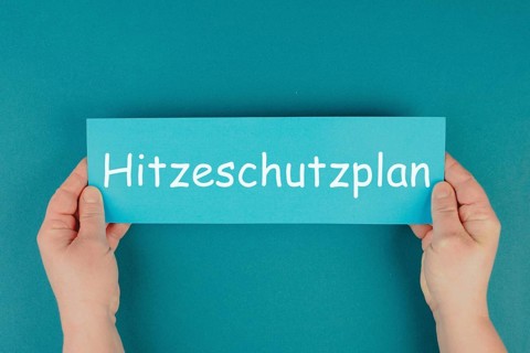 Heat protection plan stands in german language on the paper, regulation for warm summer days,