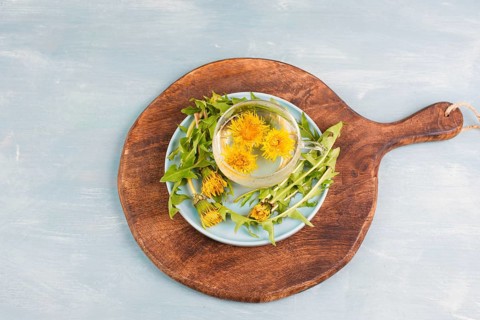 Dandelion wildflower tea, glass with herbal hot drink, alternative medicine for detox, leaves and