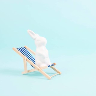 Bunny or rabbit sitting on lounge chair, easter holiday, vacation by the sea