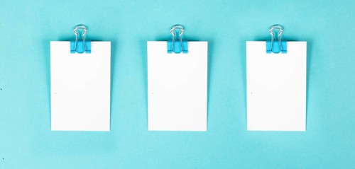 Blank white paper with a paperclip, reminder or message in the office, communication concept