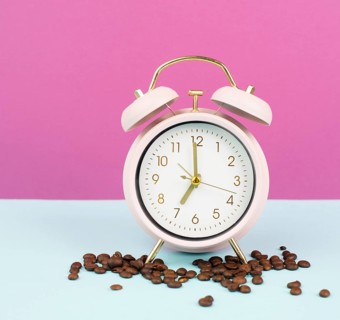 Alarm clock with roasted coffee beans, wake up in the morning, time to stand up, hot drink for