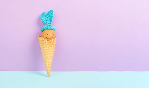 Cute easter bunny or rabbit with a smiling egg face in an ice cream cone, spring holiday, greeting