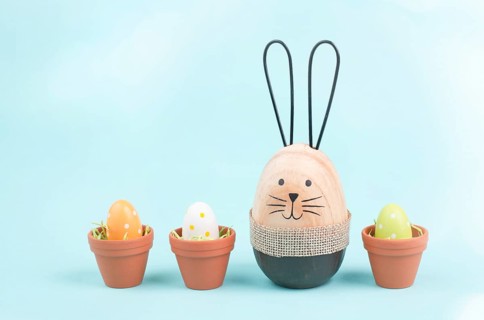 Cute easter bunny, baby rabbit with eggs in a flower pot, spring holiday greeting card