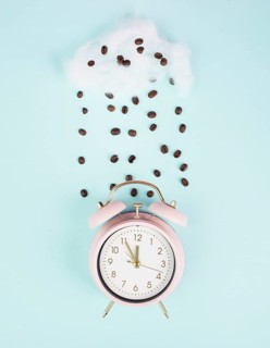 Wake up, time for a coffee break, alarm clock with roasted beans raining from a cloud