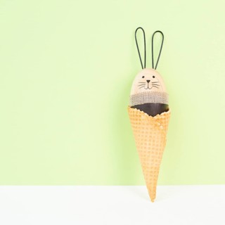Cute easter bunny or rabbit in an ice cream cone, spring holiday, greeting card