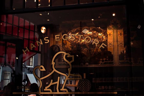 Retro shop window with gold-coloured lion emblem, stylised windows and ornate vintage-style