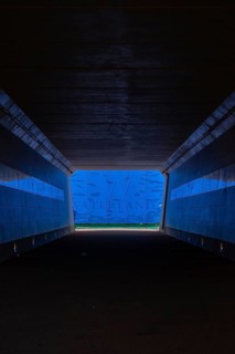 A tunnel with blue lighting ends in an exit with a water landscape and the inscription Waterland,