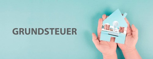 Holding a house in the hand with Euro banknotes and a stamp, new law for property tax in Germany