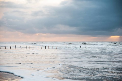 Wadden sea at low tide, North sea beach landscape, coast on Romo island in Denmark at sunset,