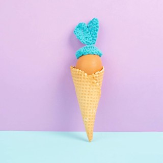 Cute easter bunny or rabbit with an egg face in an ice cream cone, spring holiday, greeting card