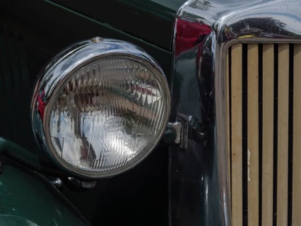 Close-up of a headlight of a green vintage car with chrome accents, winterswijk, gelderland, the