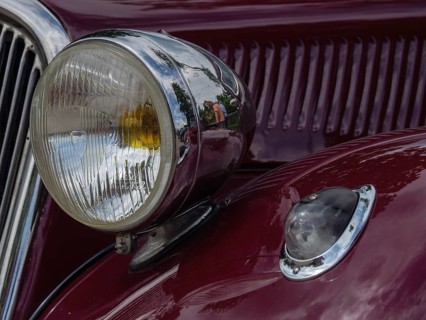 Headlights of a red vintage car that conveys a sense of nostalgia and classic design, winterswijk,