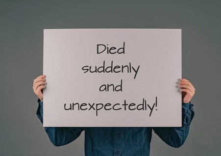 Died suddenly and unexpectedly, young man holds sign, clarification of the increase of mortality,