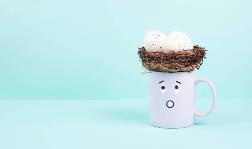 Cup with an easter egg nest, surprised face, spring holiday greeting card