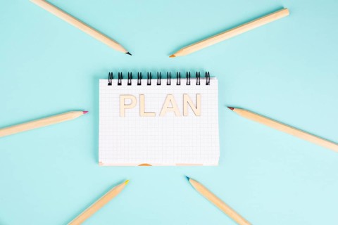 Plan is standing in a notebook, planning new goals, to do list, colorful pencils, new year