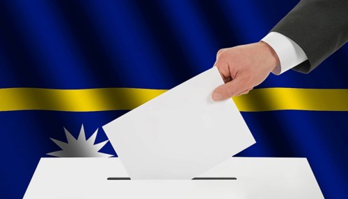 The Nauru flag and the hand with the bulletin about the ballot box