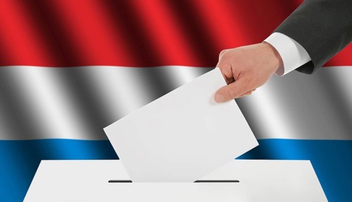 The Luxembourg flag and the hand with the bulletin about the ballot box