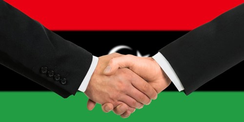 The Libyan flag and business handshake