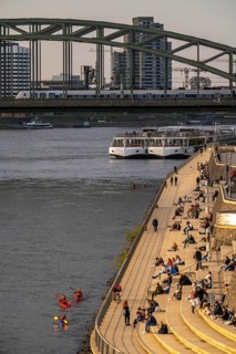 Rhine promenade, Rhine boulevard, on the Deutz bank, people sitting in the spring sun on the Rhine,