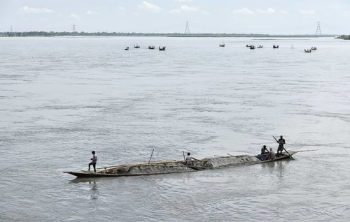 Labourer carries extracted sand from Beki River, in Barpeta district in Assam, India on Sunday