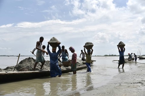 Labourer carries extracted sand from Beki River, in Barpeta district in Assam, India on Sunday