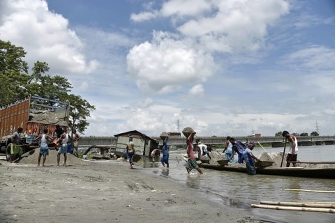 Labourer carries extracted sand from Beki River, in Barpeta district in Assam, India on Sunday
