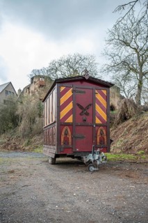 Decorative Trailer made of wood, Christmas market stand on a trailer in front of an old castle,