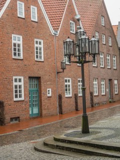 Quiet old square with brick houses and historic lanterns on cobblestones, stade, germany
