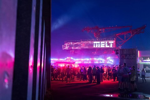Festival visitors in front of an excavator with logo at the Melt Festival in Ferropolis on 12 July
