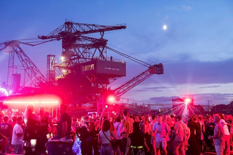 Festival visitors celebrate between excavators at the Melt Festival in Ferropolis on 12 July 2024.