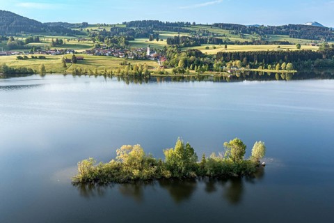 Aerial view over lake Rottachsee to village Petersthal, island in the lake, Allgäu, Bavaria,