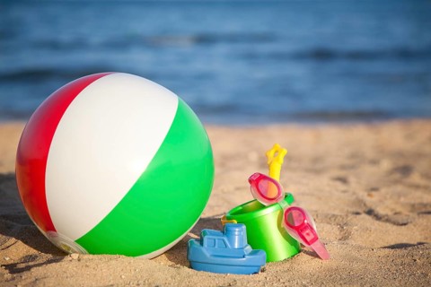 Children's toys for sand and inflatable ball at the beach. Summer vacations concept