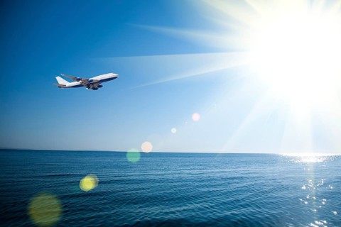 Airplane flying over the sea. Vacations concept