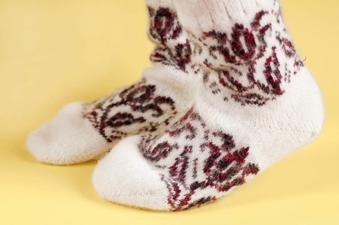 Children's feet in wool socks on a yellow background