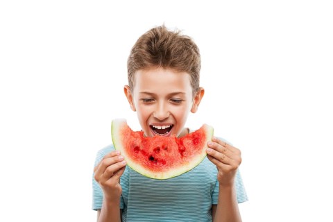 Handsome smiling child boy hand holding red ripe watermelon fruit food slice white isolated