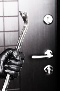 Crime scene, criminal thief or burglar hand in gloves holding metal crowbar break opening home door