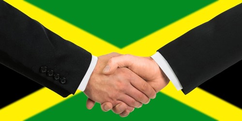 The Jamaica flag and business handshake