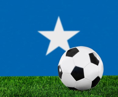 The Somalia flag and soccer ball on the green grass