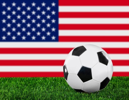 The USA flag and soccer ball on the green grass