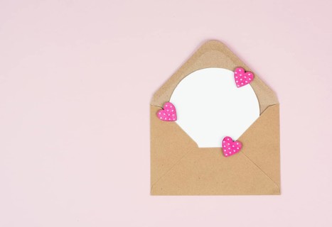 Valentine day greeting card, envelope with hearts on pastel background, love symbol, flat lay