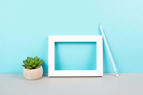 Home interior poster mock up with wooden frame, cactus in a pot, blue wall background, copy space