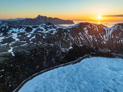 Aerial view of icy lake in front of steep mountains, coast, winter, sunrise, Storvatnet,