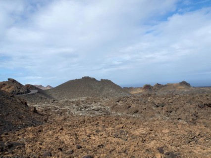 Extensive volcanic landscape with rocky hills under a blue-grey sky, arrecife, Lanzarote, Canary