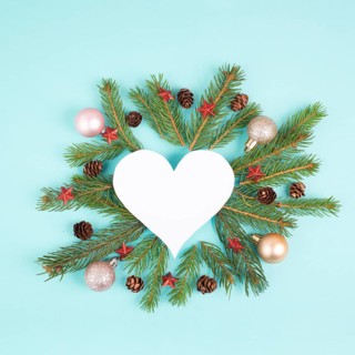 Christmas holiday background in heart shape, frame with fir branches, baubles and pine cones,