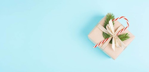 Christmas holiday greeting card with little gift box, candy cane, ribbon and fir branches, blue