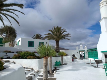 White buildings with palm trees and gardens under a cloudy sky, arrecife, Lanzarote, Canary